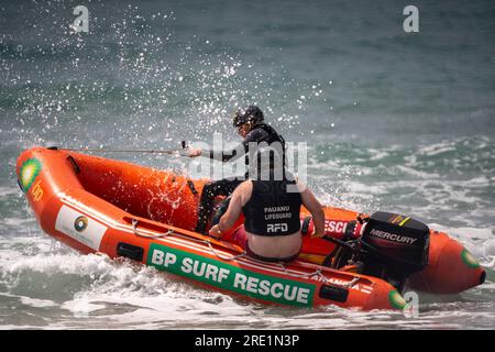 Two surf life savers patrol Paunanui Beach in a small RIB safety boat on New Zealand's North Island. Credit: Rob Taggart/Alamy Stock Photo