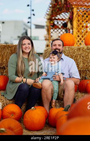 Happy Halloween and Thanksgiving - a smiling family and a little daughter on the background of orange pumpkins on holiday Stock Photo