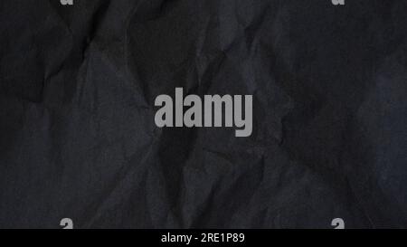 Dark abstract textile background texture. Black crumbled paper texture. Stock Photo