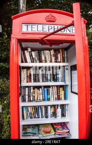 Red British telephone box used as book lending library Stock Photo