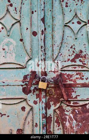 Rusty metallic door with a padlock Stock Photo