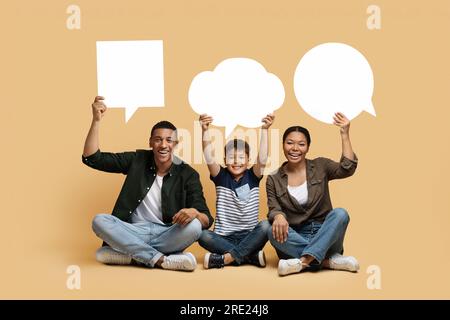 Black mom, dad and son holding different empty speech bubbles Stock Photo