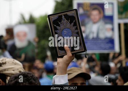 Sanaa, Yemen. 24th July, 2023. A Yemeni man holds a copy of the Quran during a protest in Sanaa to denounce the burning of Islam's holy book the Quran in the Swedish capital Stockholm. Credit: Hani Al-Ansi/dpa/Ģ����ý Live News Stock Photo