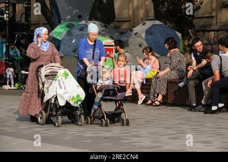 Kazakhstan, Almaty. Kazakh Women Pushing their Children in Baby Carriages on the Panfilov Promenade, a Pedestrian Walkway. Stock Photo