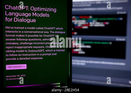 Azores, Portugal - 16.01.2023: SmartPhone Screen with AI Chat GPT home page. Developed by OpenAI. In the background a laptop screen with ChatGPT code Stock Photo