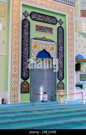 Kazakhstan, Almaty. Baiken Mosque Interior Showing Mihrab and Worshiper Praying. Stock Photo