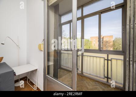 Apartment with furnished living room with access to a terrace with glass and aluminum enclosure overlooking the open countryside Stock Photo