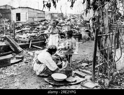 Yokohama, Japan:  November 7, 1923 A baby getting his bath amongst the ruins left over from the Great Kanto Earthquake. in September. Stock Photo