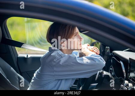 Pensive serious woman standing in traffic jam waiting driving car looking ahead. Stock Photo