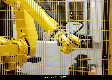 Collaborative robot and CNC machine in work cell. Selective focus. Stock Photo