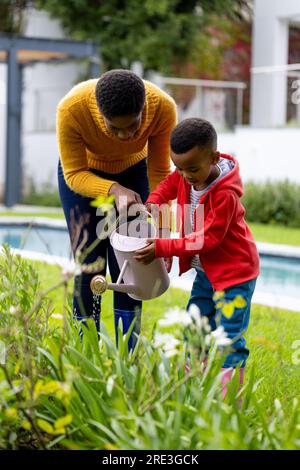 African American father and son are watering plants together Stock ...