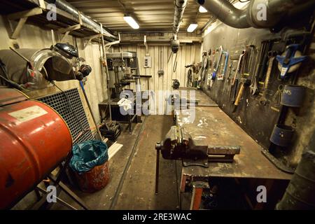 Dirty workshop with tools on the wall located on old jack up rig. Stock Photo