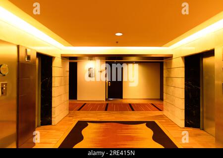 Bangkok, Thailand - October 22, 2020 : Empty hallway in the hotel with colorful walls and warm light. Stock Photo