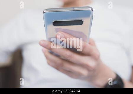Using a smartphone for everyday purposes. Close-up on the phone in hand. Selective soft focus Stock Photo