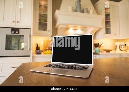 Laptop with blank black screen placed on wooden table at home, copy space Stock Photo