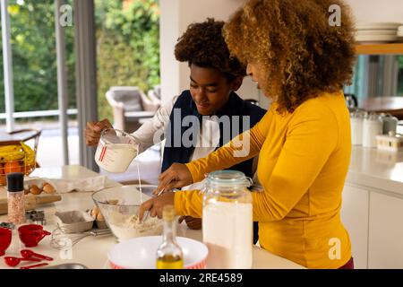Happy african american mother and son baking in kitchen Stock Photo