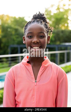 Portrait of happy african american girl on sunny terrace at home Stock Photo