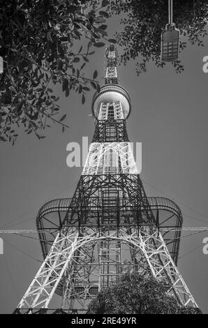 Looking up at a tall red and white steel radio and communications mast or tower close to Reunifcation Park against a blue sky in Hanoi Vietnam. Stock Photo