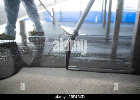 Crop unrecognizable people pouring concrete on floor Stock Photo