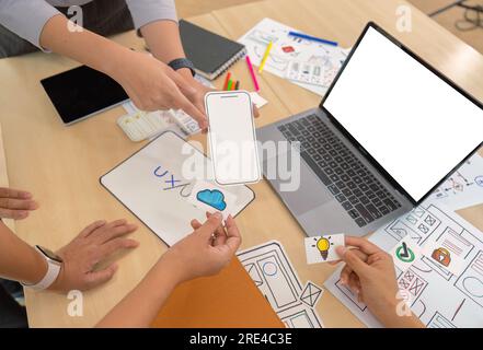 Close up ux developers and ui designers listening to mobile app presentations in conference in front of laptop Stock Photo