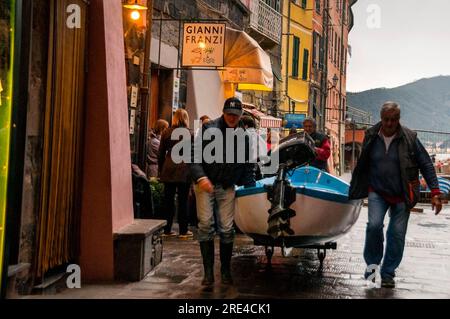 Fishermen pulling their boat ashore in the small fishing village of Vernazza in Cinque Terre, Italy. Stock Photo