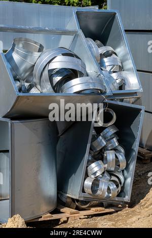 Connecting pipes for air ducts in the box. Various sheet metal air ducts in stock for installation in a building under construction. Ventilation syste Stock Photo