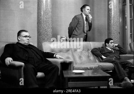 UK men watching TV 1970s. Television in the lobby of a Manchester hotel. Two guests and the hotel porter. Manchester, England 1972. HOMER SYKES. Stock Photo
