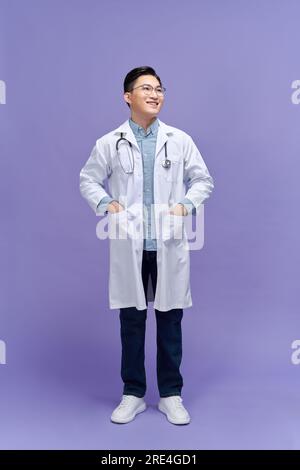 Handsome young man wearing doctor uniform with a happy and cool smile on face Stock Photo
