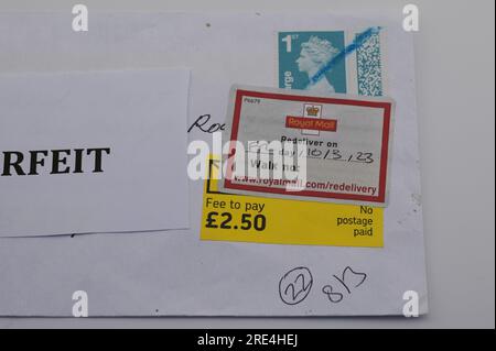 England, 25th July 2023: When a fake Royal Mail stamp is detected through the post, it is held back until the receiver pays a fee as it is recorded as 'No postage paid'. - Counterfeit Royal Mail barcoded stamps are for sale on eBay at a fraction of the genuine price. Sheets of 50 stamps are for sale as low as 15 pounds (GBP) and to the unsuspecting eye look real. However under UV light, small differences can be seen. Credit: Stop Press Media/Alamy Live News Stock Photo