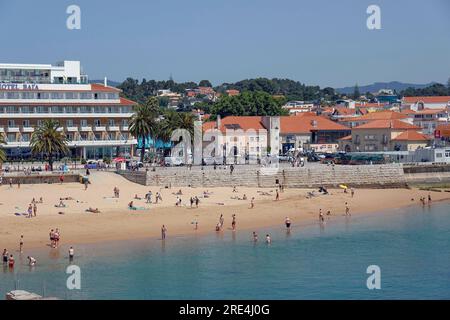 Portugal, Cascais (Lisbon) - Seaside town  is an important tourist destination. .Sunbathers on the beach at Cascais with the three-star Hotel Baia ove Stock Photo