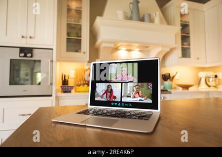 Laptop with video conference with diverse students on a table in the kitchen Stock Photo