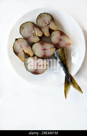 Cold smoked mackerel cut into slices on a white background. Top view. Gourmet food. Stock Photo