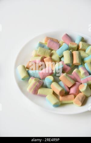 Colorful sweet marshmallows on a white plate. Delicious marshmallows for coffee. Stock Photo