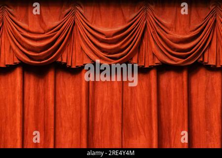 Red velvet curtain with wavy drapes, background photo texture Stock Photo