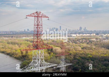 Aerial view of electricity pylon and high voltage line against city center Stock Photo