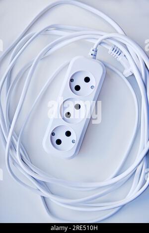 White electric extension cord, great design for any purposes. White background. Network extension cord. Stock Photo