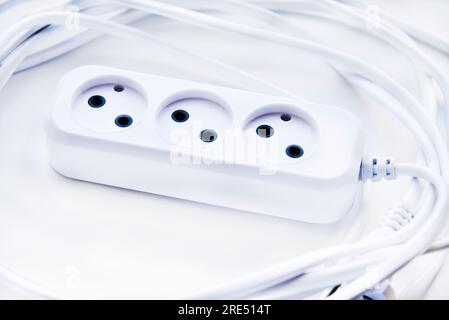 White electric extension cord, great design for any purposes. White background. Network extension cord. Stock Photo