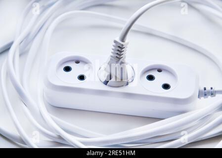 White electric extension cord, great design for any purposes. White background. Network extension cord. Stock Photo