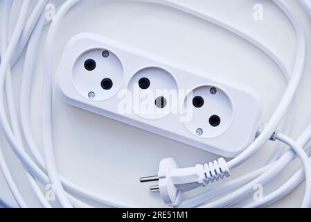 White electric extension cord, great design for any purposes. White background. Network extension cord. Stock Photo