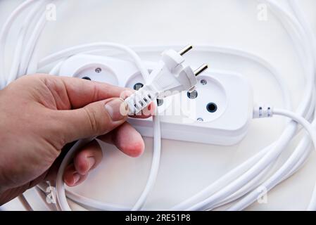 White electric extension cord, great design for any purposes. White background. Network extension cord. Stock Photo