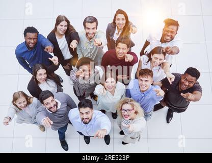 large team of young people pointing somewhere up Stock Photo
