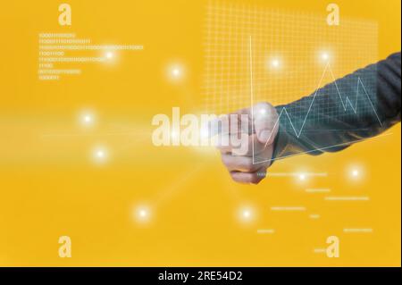Male hand performing a presentation on virtual interface with financial graphs and binary code digits glowing over yellow background. Stock Photo