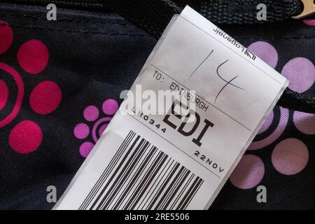 Loganair luggage label stuck on case for EDI Edinburgh airport in Scotland Stock Photo