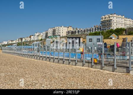 New swimming pool, cafes and restaurants on beach at Brighton, East Sussex, England. With people in pool and cafes. Stock Photo