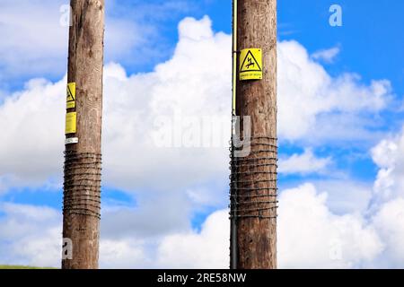 Yellow signs warning of danger electricity overhead Stock Photo