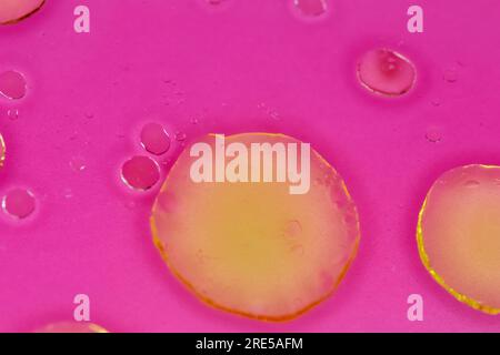 yellow bubbles of oil on pink liquid, background with abstract colorful bubbles. Macro detail for chemistry and research backgrounds Stock Photo