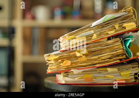 stack of dusty messy file folders with narrow depth of field, blurred ...