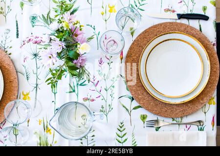 Spring floral table set, with white empty plate. Spring happy brunch and lunch in sunny day. Flower pattern decoration and simply lifestyle Stock Photo