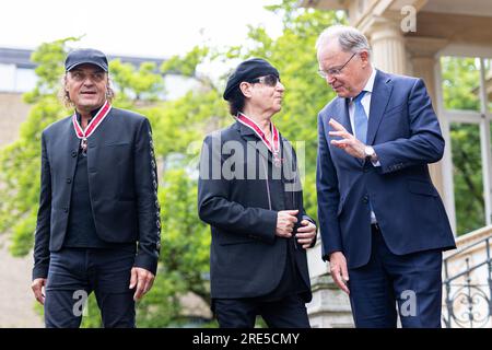 Hanover, Germany. 25th July, 2023. Matthias Jabs (l-r), band member of the 'Scorpions', Klaus Meine, band member of the 'Scorpions', and Stephan Weil (SPD), Minister President of Lower Saxony, stand in the garden of the guest house of the state government after receiving the Grand Cross of Merit of the Order of Merit of Lower Saxony. Three band members of the rock band 'Scorpions' are honored for their music as well as their honorary commitment in Lower Saxony. Credit: Michael Matthey/dpa/Alamy Live News Stock Photo