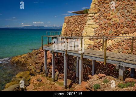 Wooden footbridge of the Salou coastal path surrounding the old lazaretto from 1829 (Tarragona, Catalonia, Spain) ESP: Pasarela de madera en Salou Stock Photo